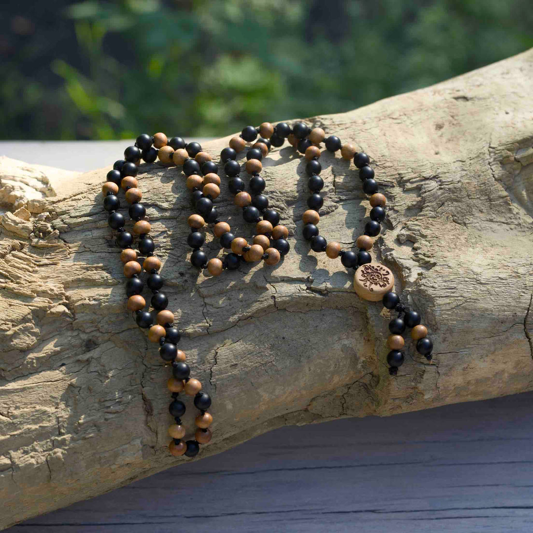 Malasonne Guruperle aus Holz mit OM-Zeichen und Sonnenstrahlen – handgefertigtes Detail der Malakette Krafthüter von Malawelt