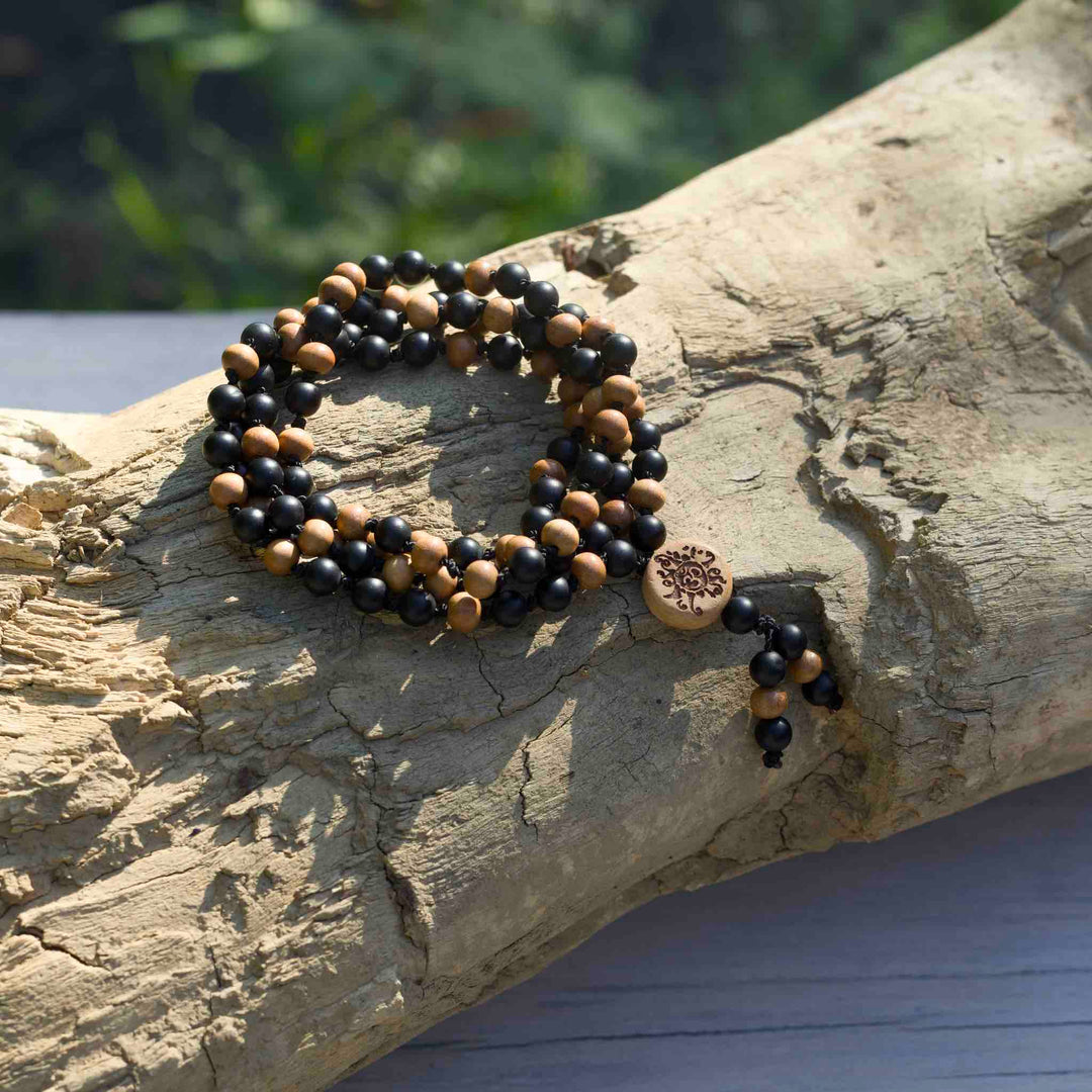 Nahaufnahme der 6mm Perlen aus mattem Onyx und Sandelholz – handgeknüpfte Meditationskette Krafthüter von Malawelt