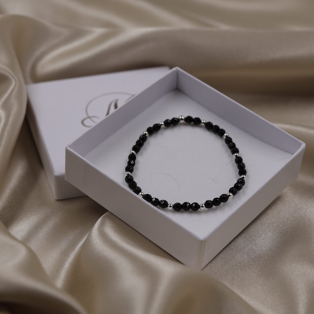 Onyx Handala im Rhythmus-Design mit Silberkugeln zwischen 4mm facettierten Onyx-Perlen, handgefertigt von Malawelt.